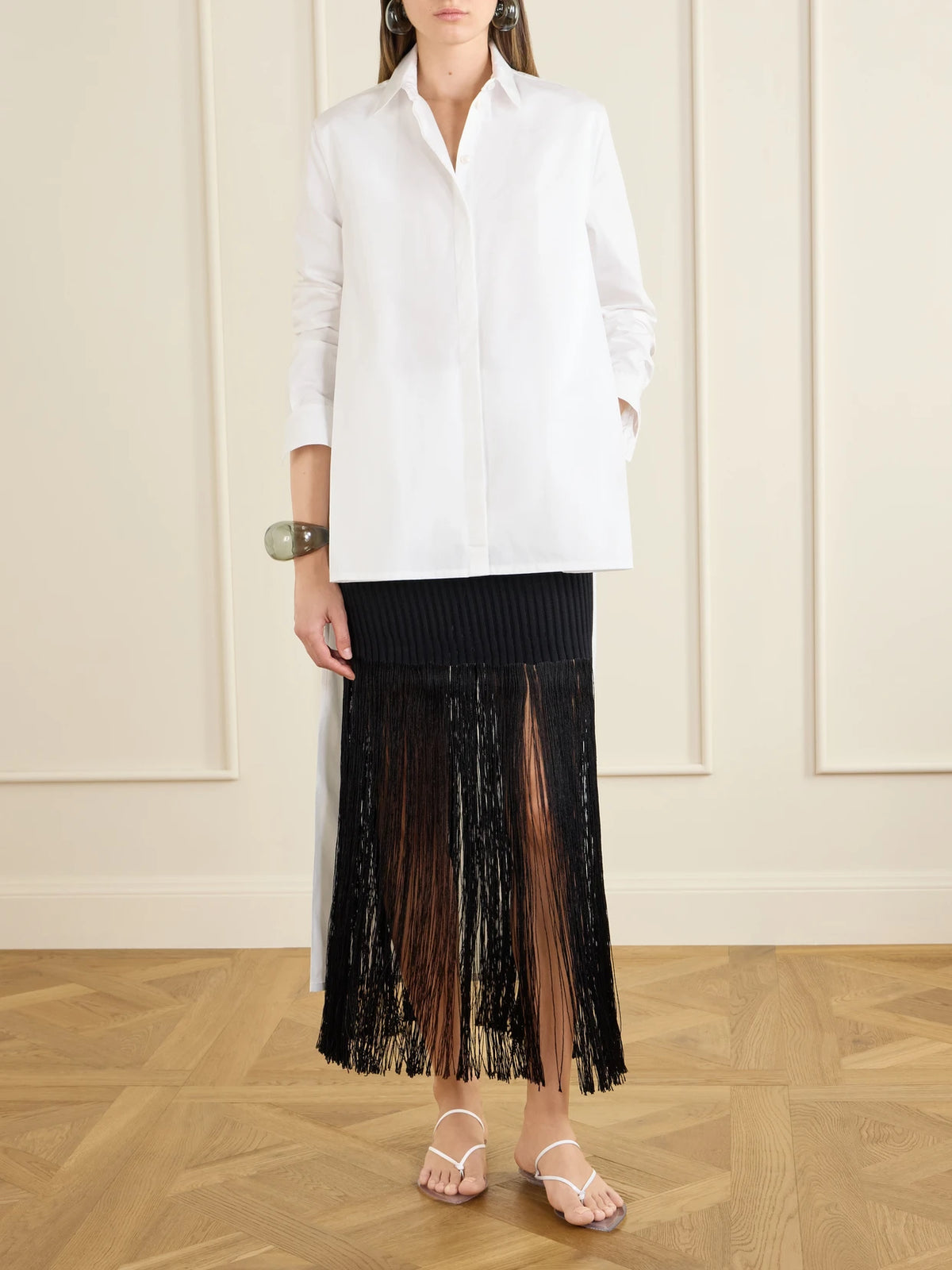 Image of a model wearing Skirts. Product name - Ribbed Fringed Jersey Midi Skirt in Black colour by brand - Alaïa
