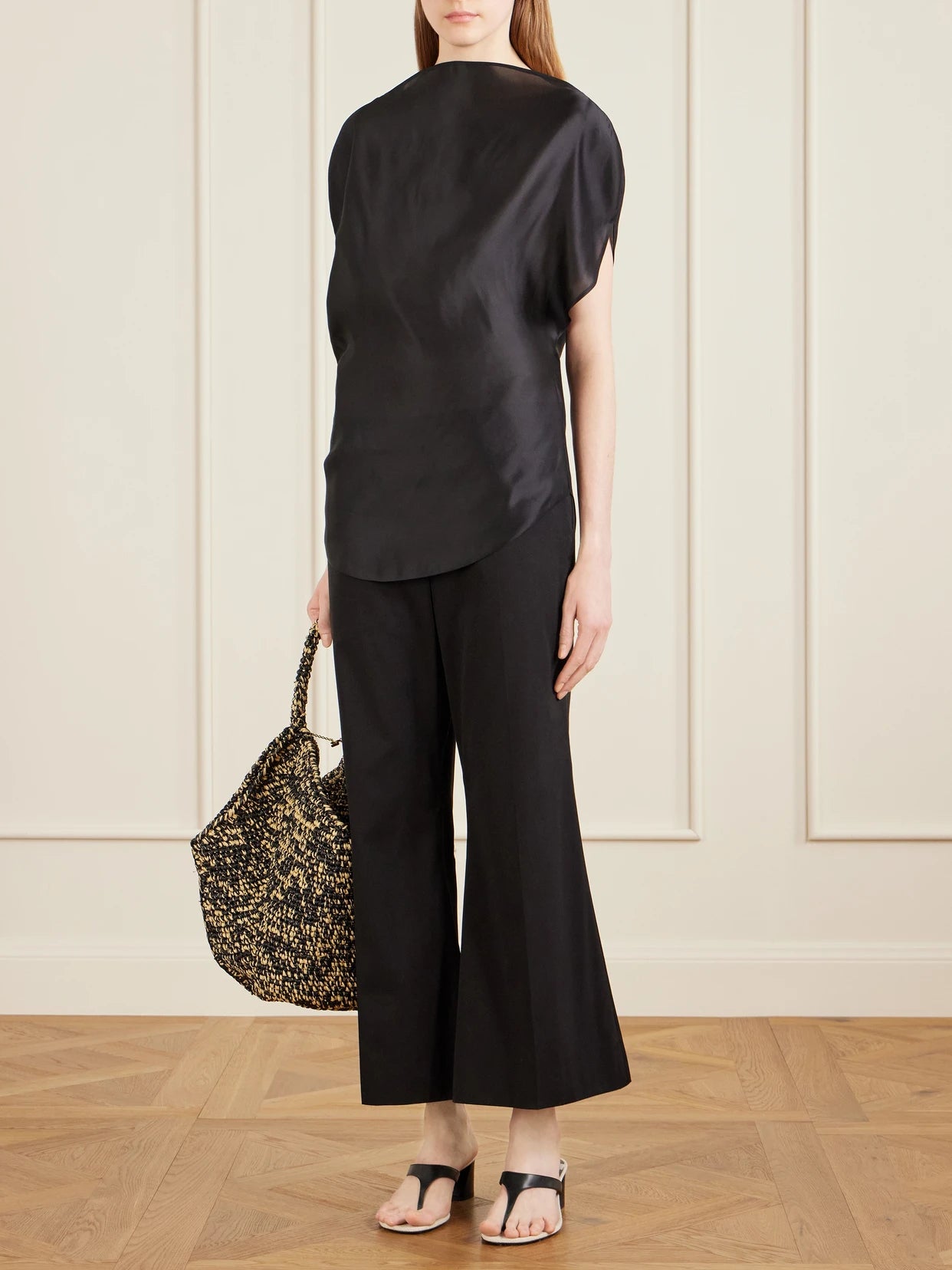 Image of a model wearing Pants. Product name - Walter Cotton And Silk-blend Flared Pants in Black colour by brand - KHAITE