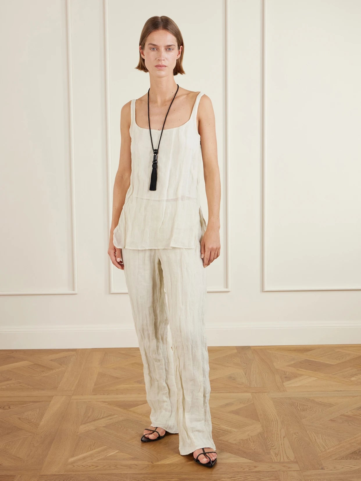 Image of a model wearing Pants. Product name - Crinkled Cotton-blend Wide-leg Pants in Cream colour by brand - RÓHE