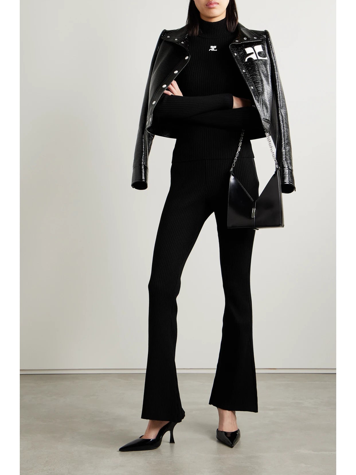 Image of a model wearing Outerwear. Product name - Reedition Embroidered Ribbed-knit Turtleneck Sweater in Black colour by brand - COURREGES
