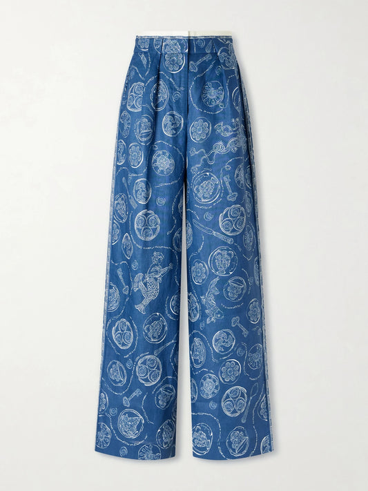 Image of a model wearing Pants. Product name - Lucky Pleated Printed Linen Wide-leg Pants in Blue colour by brand - ALÉMAIS