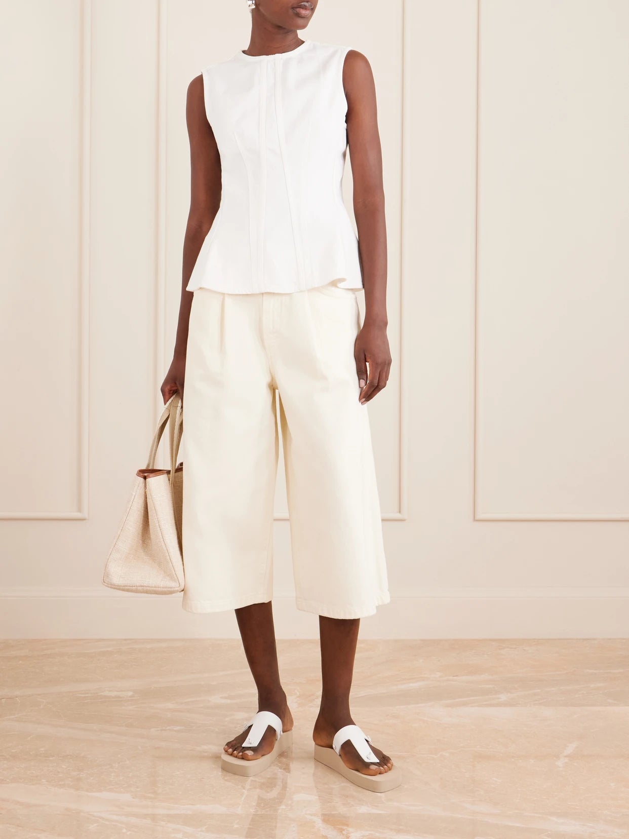 Image of a model wearing Tops. Product name - Corbin Cotton Peplum Top in White colour by brand - AGOLDE