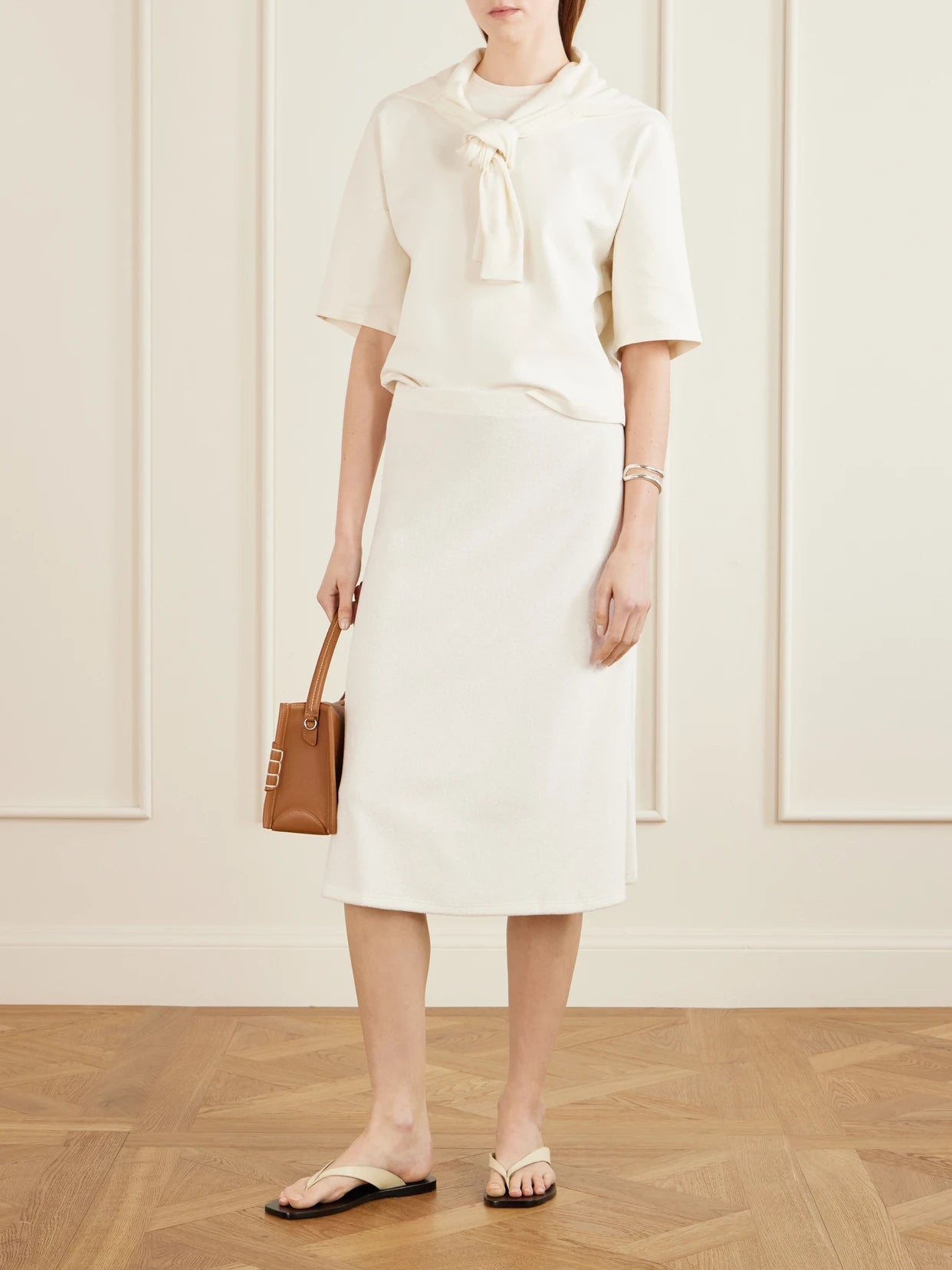 Image of a model wearing Skirts. Product name - Sienna Cotton-blend Terry Midi Skirt in Ivory colour by brand - Suzie Kondi
