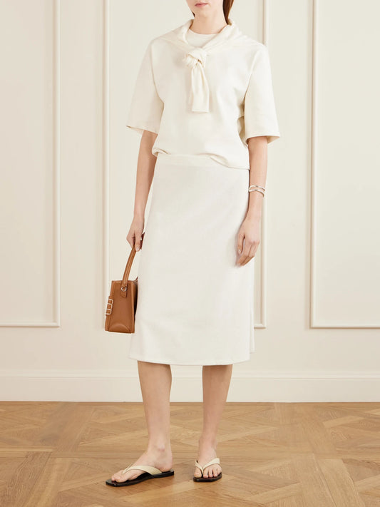 Image of a model wearing Skirts. Product name - Sienna Cotton-blend Terry Midi Skirt in Ivory colour by brand - Suzie Kondi