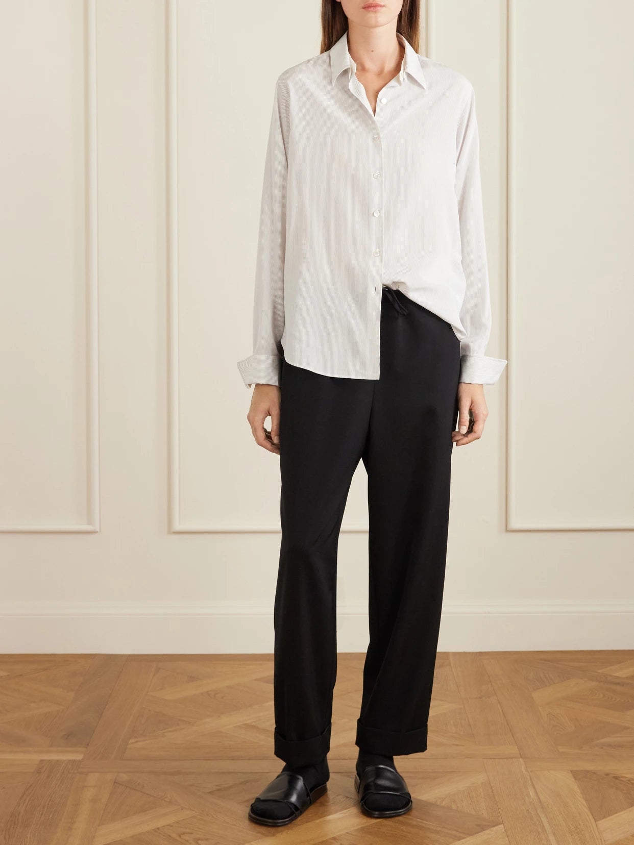 Image of a model wearing Pants. Product name - Delano Wool-twill Wide-leg Pants in Black colour by brand - The Row
