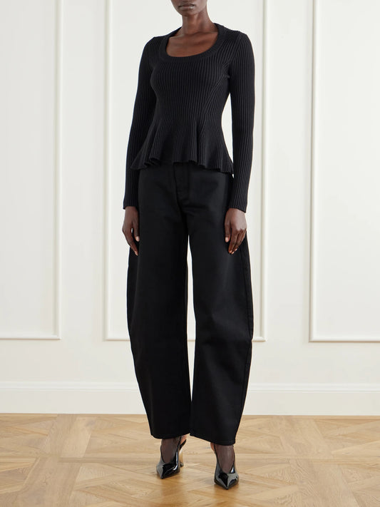 Image of a model wearing Outerwear. Product name - Ribbed Wool-blend Peplum Sweater in Black colour by brand - Alaïa
