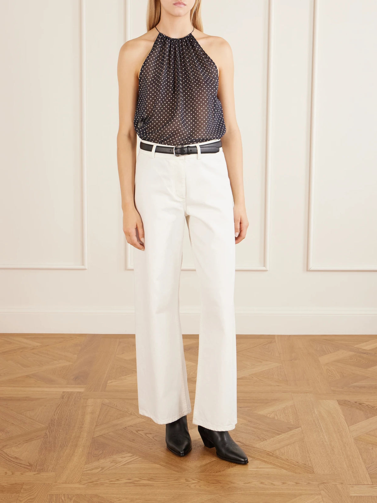 Image of a model wearing Tops. Product name - Nikki Polka-dot Silk Halterneck Tank in Black colour by brand - Nili Lotan