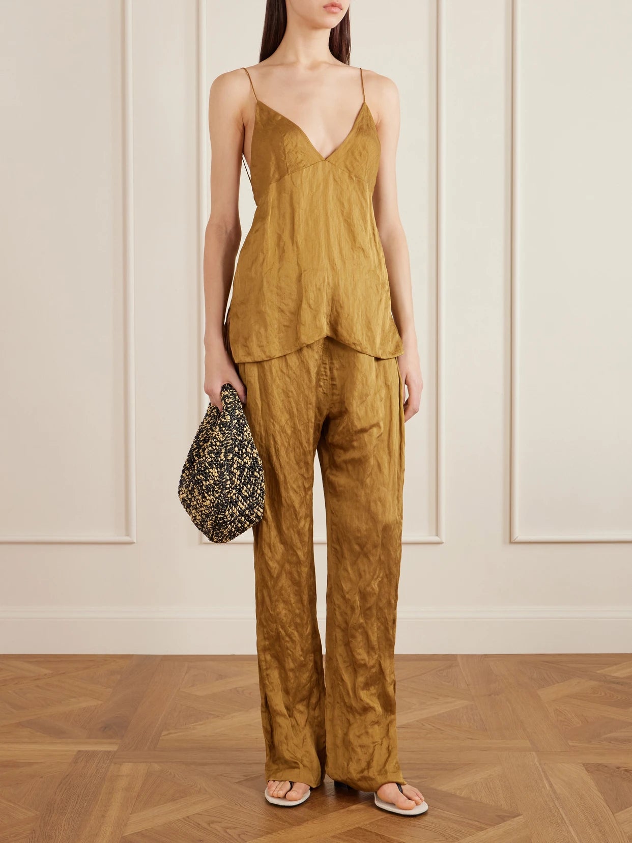 Image of a model wearing Pants. Product name - Rohen Crinkled-voile Pants in Gold colour by brand - KHAITE