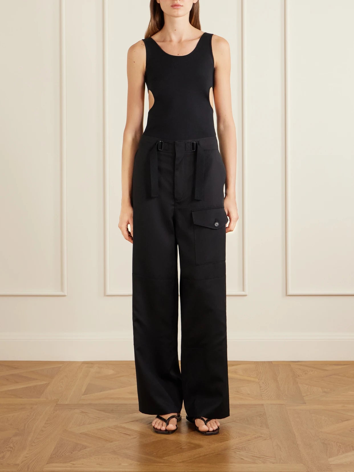 Image of a model wearing Tops. Product name - Cutout Ribbed-knit Jersey Tank in Black colour by brand - Auralee
