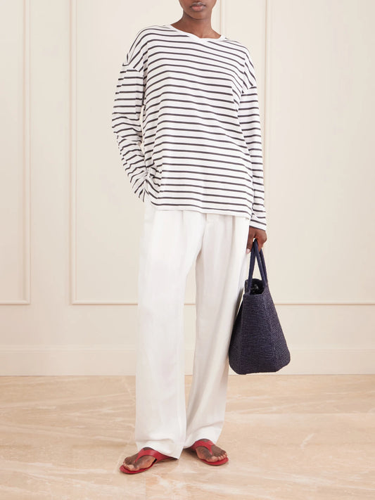 Image of a model wearing Pants. Product name - Tapered Linen-blend Pants in White colour by brand - Jamie Haller
