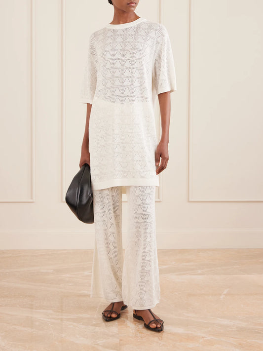 Image of a model wearing Pants. Product name - Egeo Pointelle-knit Wide-leg Pants in Ivory colour by brand - Loulou de Saison