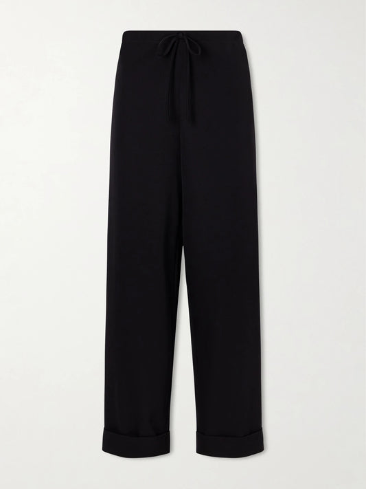 Image of a model wearing Pants. Product name - Delano Wool-twill Wide-leg Pants in Black colour by brand - The Row