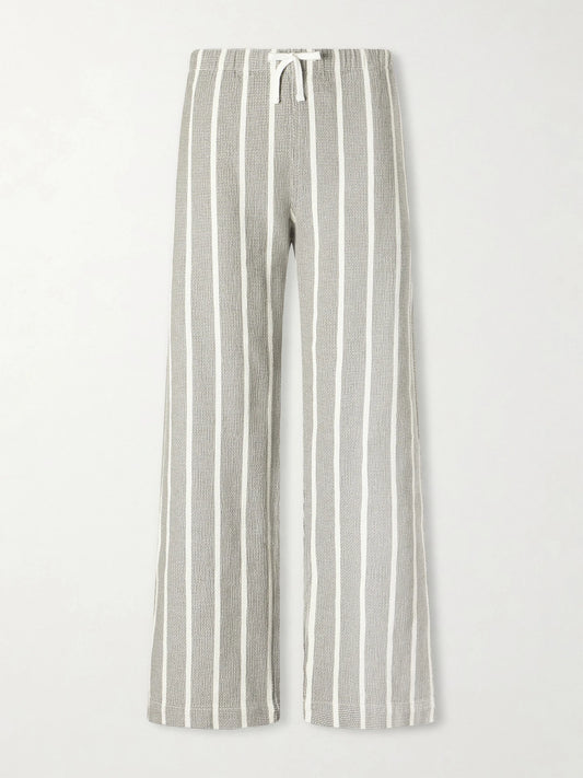 Image of a model wearing Pants. Product name - Striped-print Cotton Canvas Wide-leg Pants in Gray colour by brand - Aimé Leon Dore