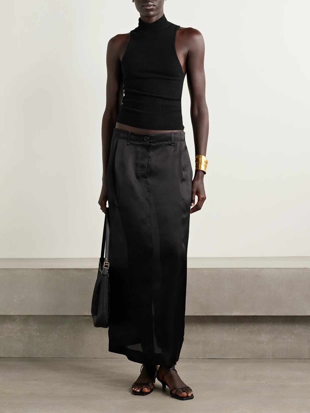 Image of a model wearing Tops. Product name - Hansen Merino Wool And Cashmere-blend Turtleneck Tank in Black colour by brand - Nili Lotan