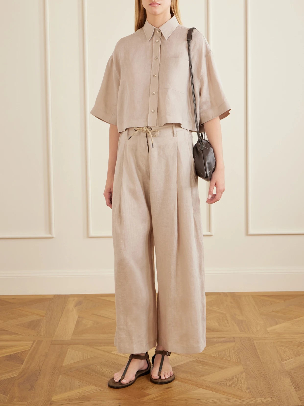 Image of a model wearing Pants. Product name - Linen Wide-leg Drawstring Pants in Sand colour by brand - Brunello Cucinelli