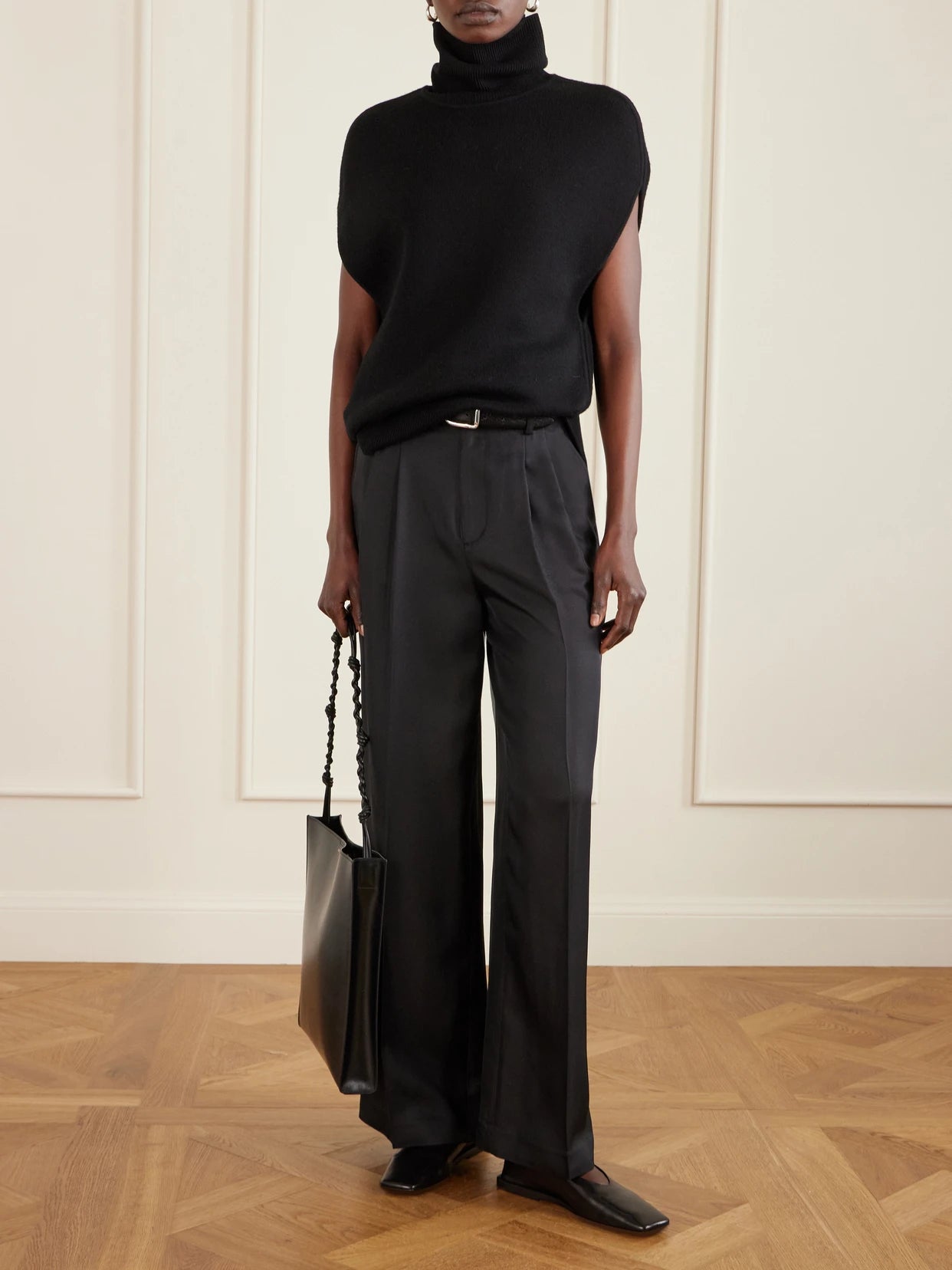 Image of a model wearing Pants. Product name - Pleated Silk-twill Wide-leg Pants in Black colour by brand - LISA YANG