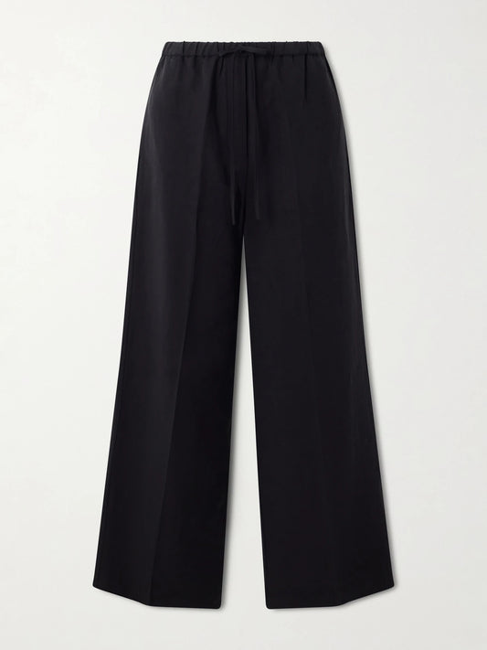 Image of a model wearing Pants. Product name - Linen Wide-leg Pants in Black colour by brand - TOTEME