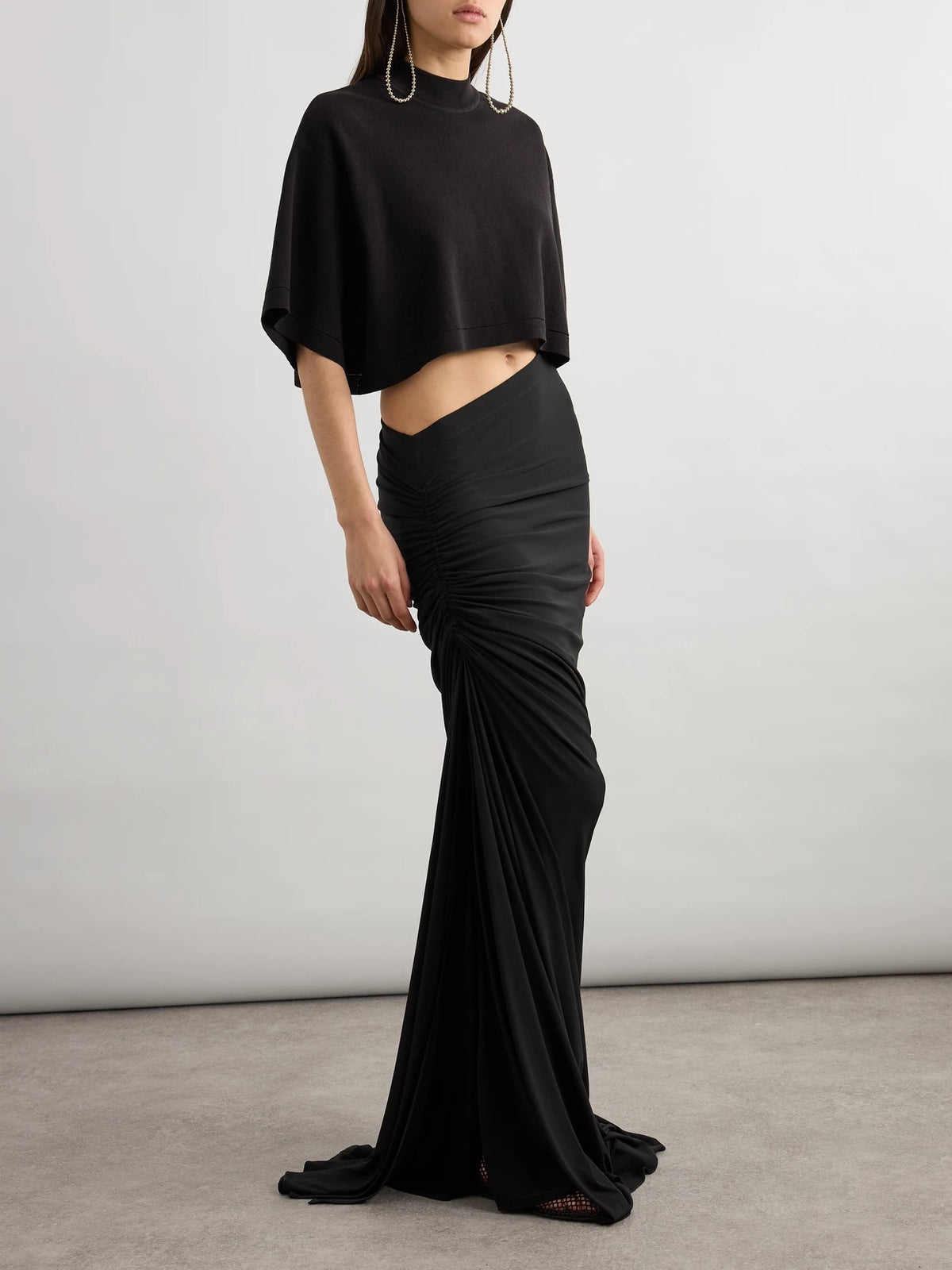 Image of a model wearing Tops. Product name - Cropped Cotton-jersey T-shirt in Black colour by brand - Alaïa