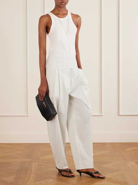 Image of a model wearing Pants. Product name - Pleated Striped Cotton And Silk-blend Straight-leg Pants in White colour by brand - TOTEME