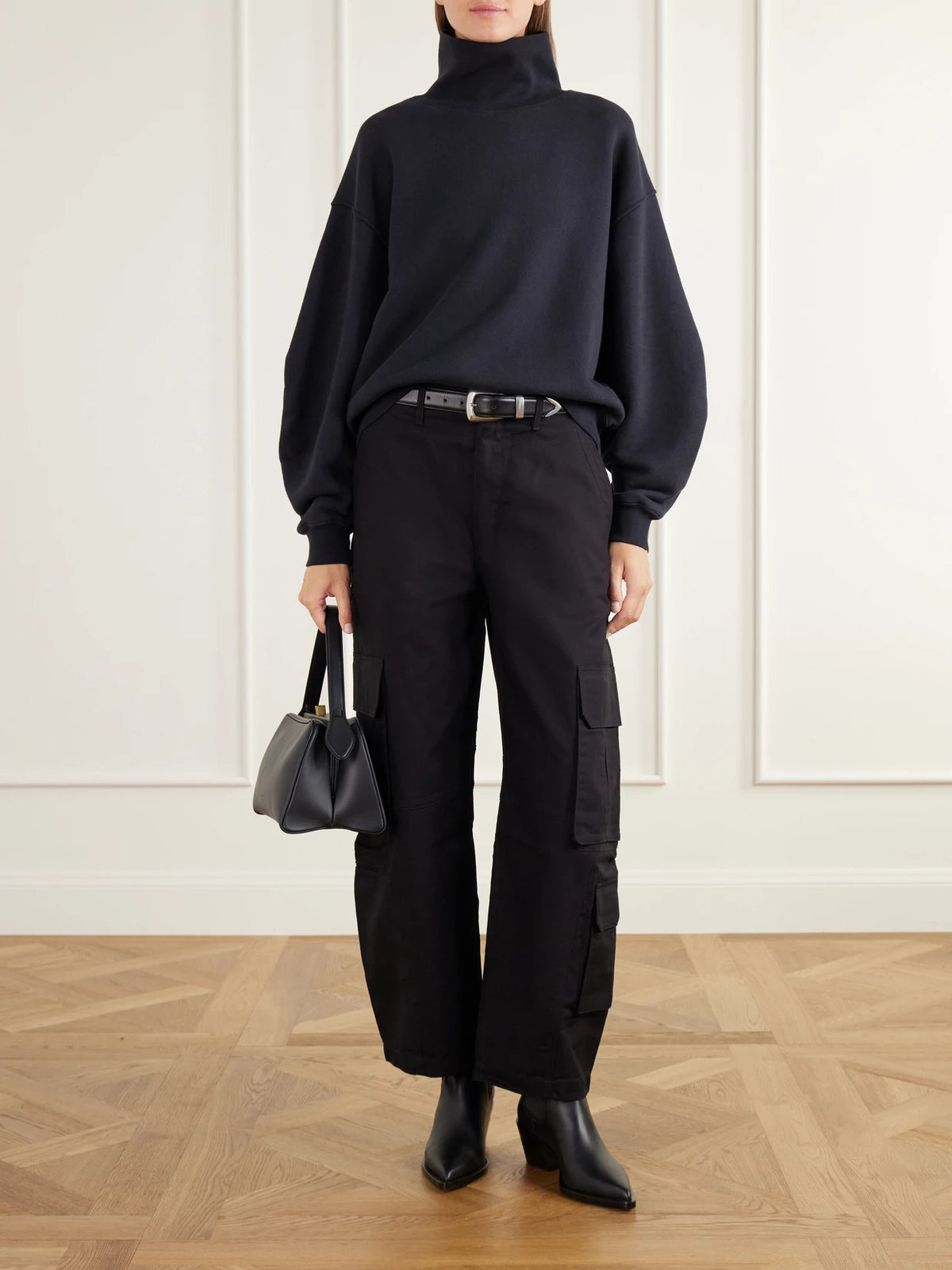 Image of a model wearing Pants. Product name - Ambika Utility Cotton-sateen Barrel-leg Pants in Black colour by brand - AGOLDE
