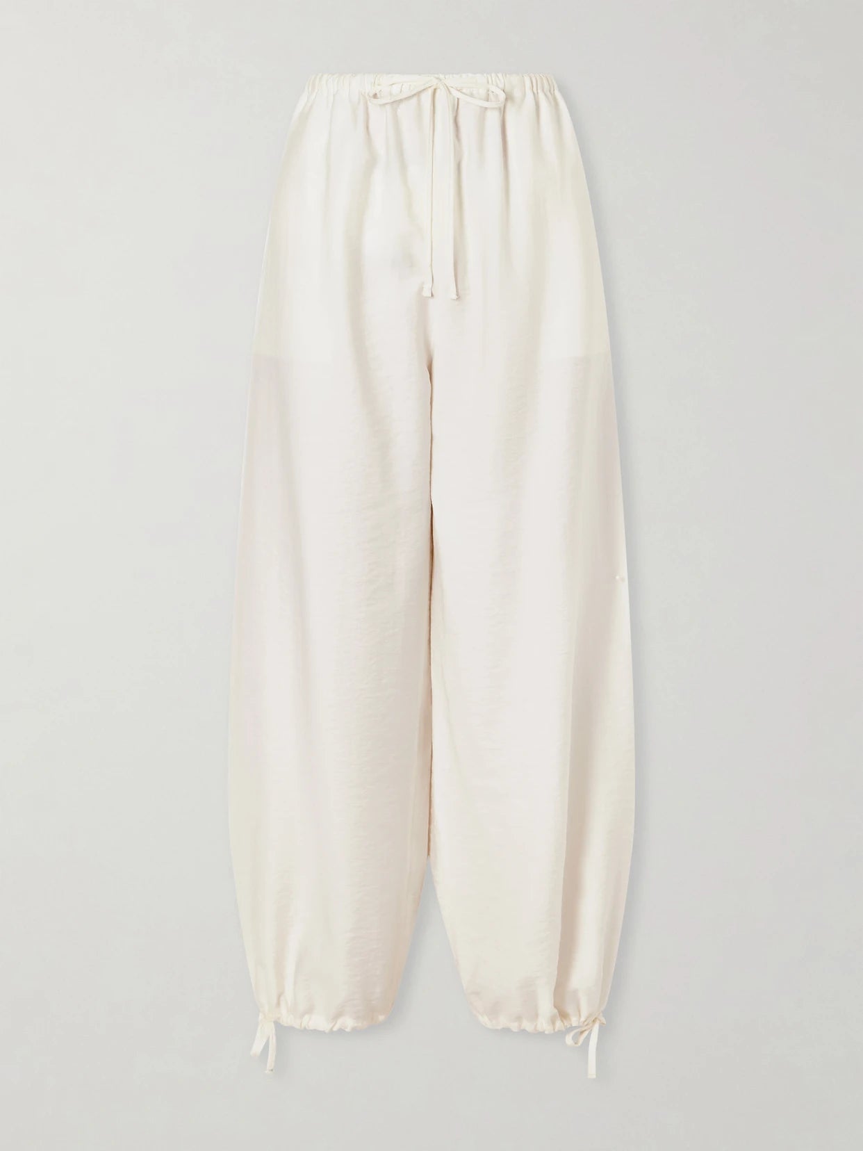 Image of a model wearing Pants. Product name - Parachute Lyocell-blend Balloon Pants in Ecru colour by brand - TOTEME