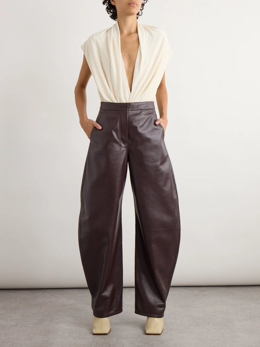 Image of a model wearing Pants. Product name - Leather Barrel-leg Pants in Dark brown colour by brand - Alaïa