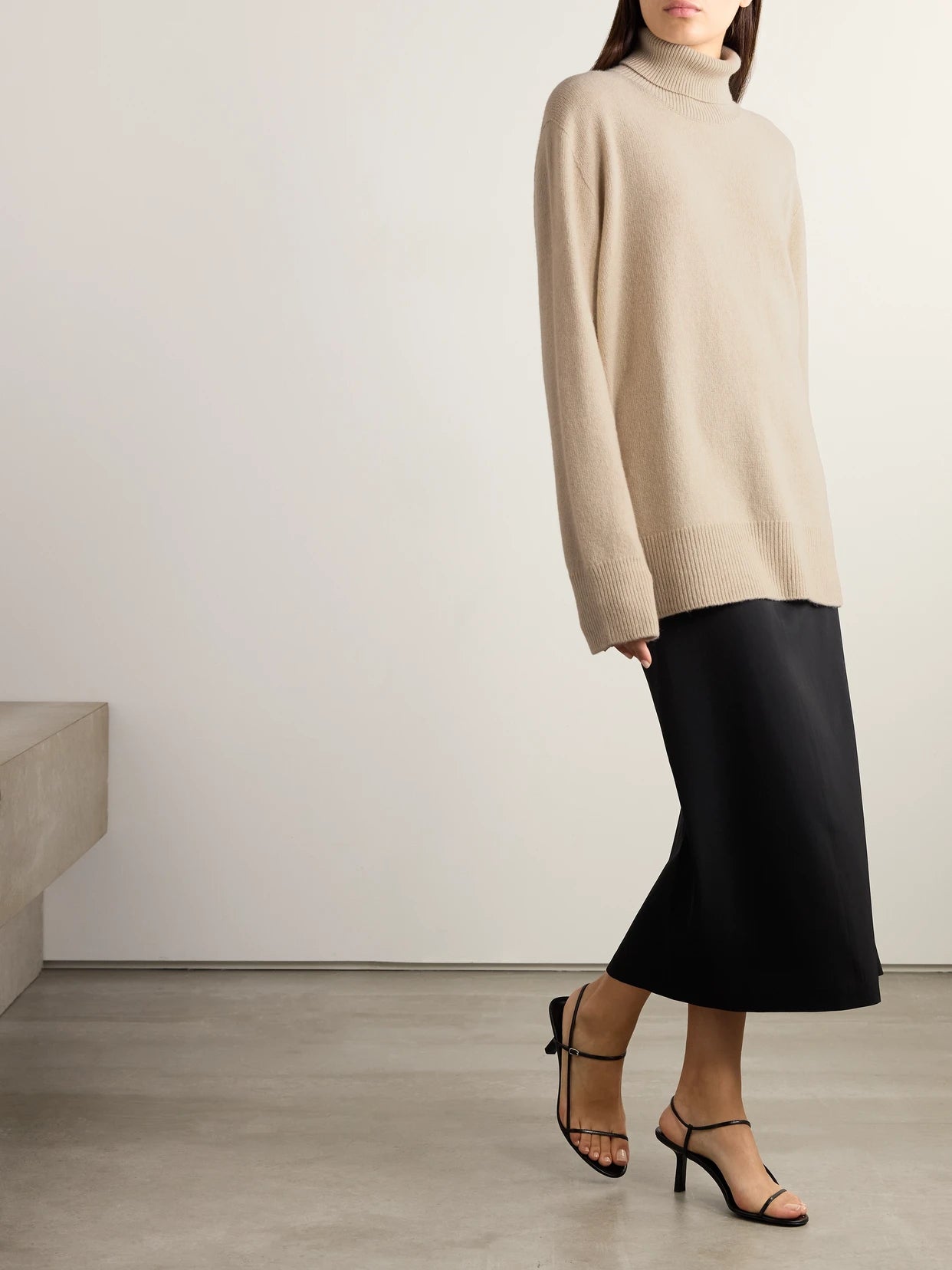 Image of a model wearing Outerwear. Product name - Stepny Oversized Wool And Cashmere-blend Turtleneck Sweater in Sand colour by brand - The Row