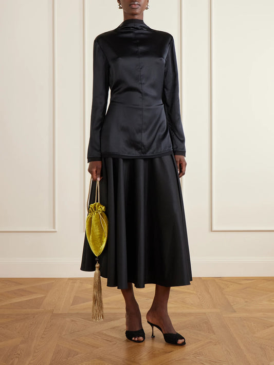 Image of a model wearing Skirts. Product name - Pleated Cotton-poplin Midi Skirt in Black colour by brand - Abadia