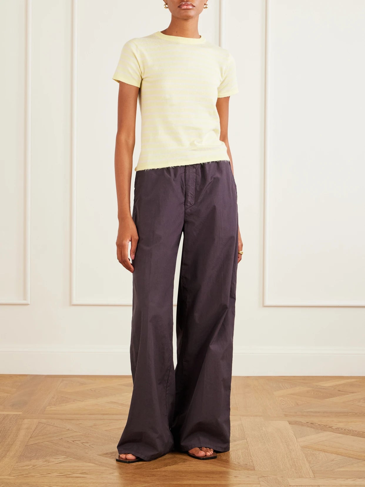Image of a model wearing Pants. Product name - Cotton Wide-leg Pants in Brown colour by brand - Auralee