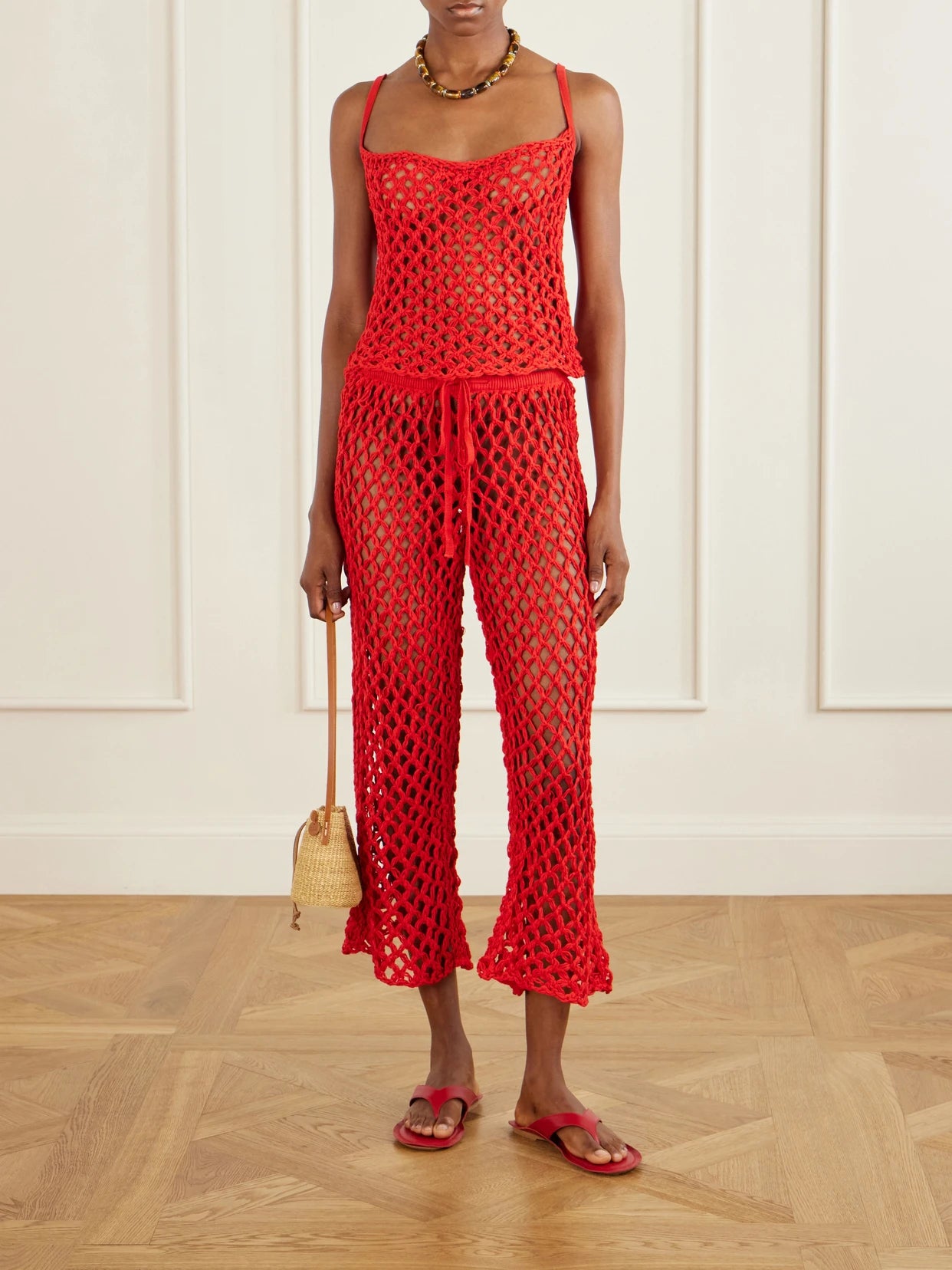 Image of a model wearing Pants. Product name - Clara Crocheted Straight-leg Pants in Red colour by brand - Haight