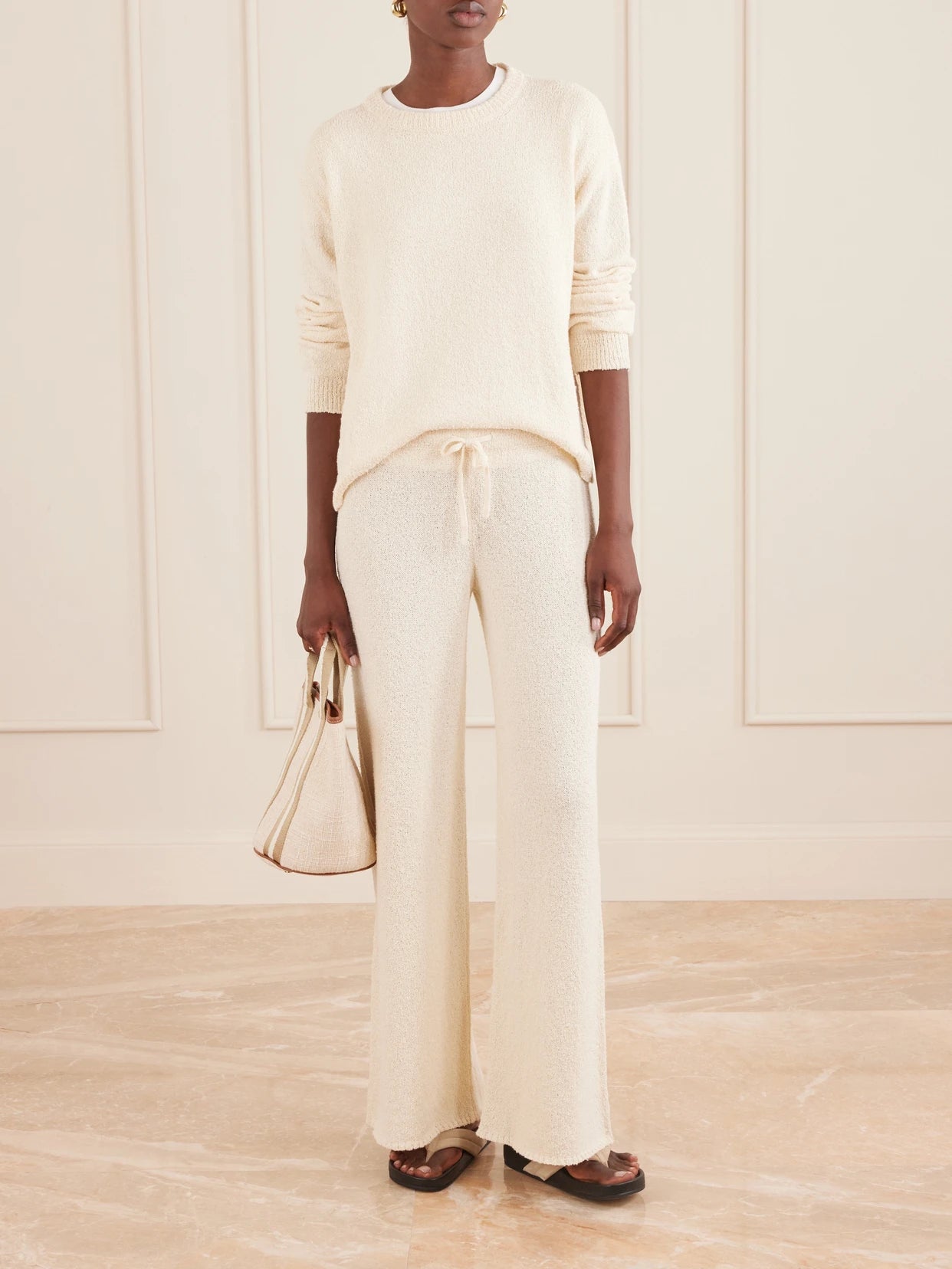 Image of a model wearing Outerwear. Product name - Kismet Knitted Cotton Sweater in Ecru colour by brand - Suzie Kondi