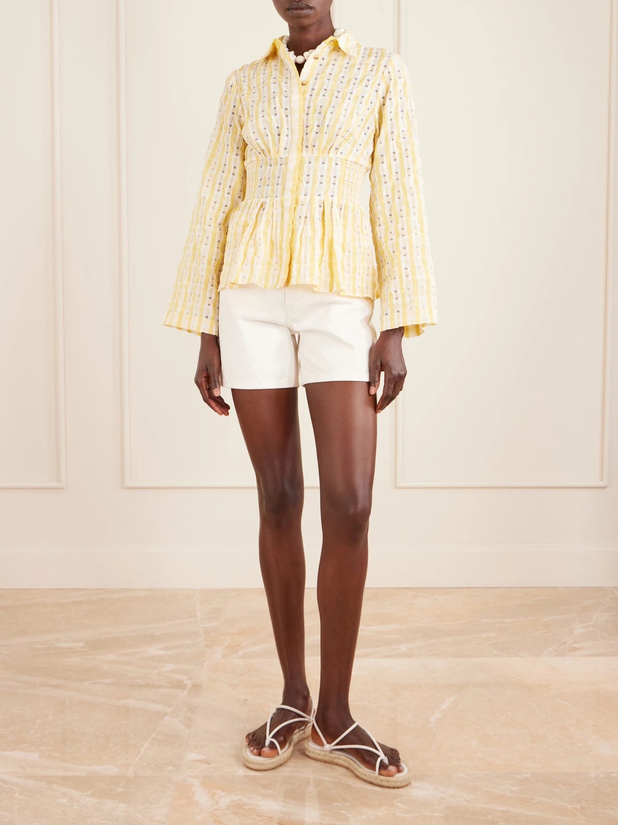 Image of a model wearing Tops. Product name - Boogie Woogie Bugle Boy Shirred Checked Seersucker Blouse in Yellow colour by brand - Rosie Assoulin