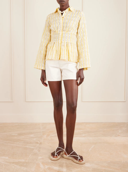 Image of a model wearing Tops. Product name - Boogie Woogie Bugle Boy Shirred Checked Seersucker Blouse in Yellow colour by brand - Rosie Assoulin