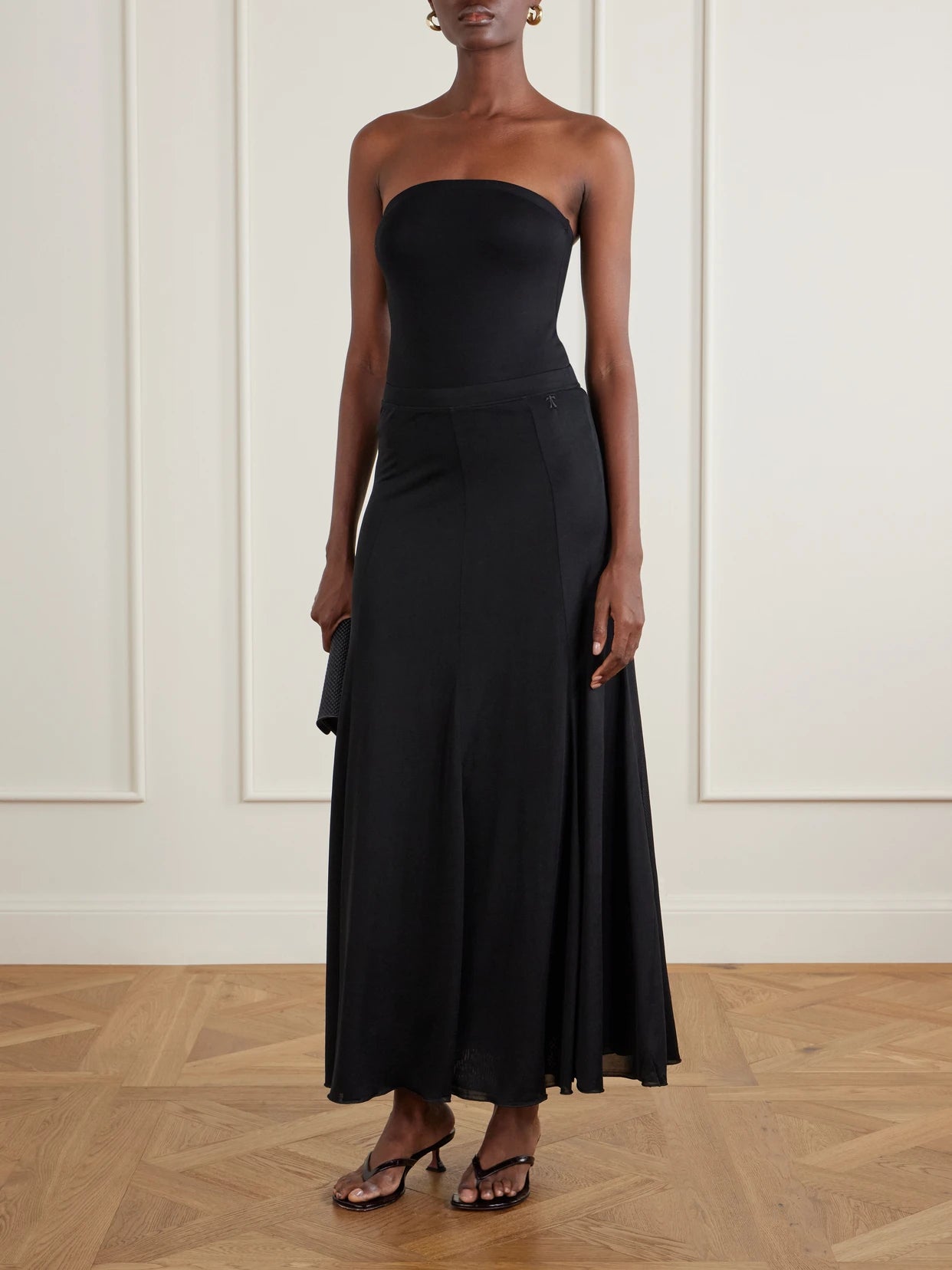 Image of a model wearing Skirts. Product name - Olivia Flowy Lyocell Maxi Skirt in Black colour by brand - THE PARK
