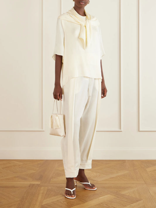 Image of a model wearing Tops. Product name - Anita Scarf-detailed Satin T-shirt in Ecru colour by brand - Sharon Wauchob