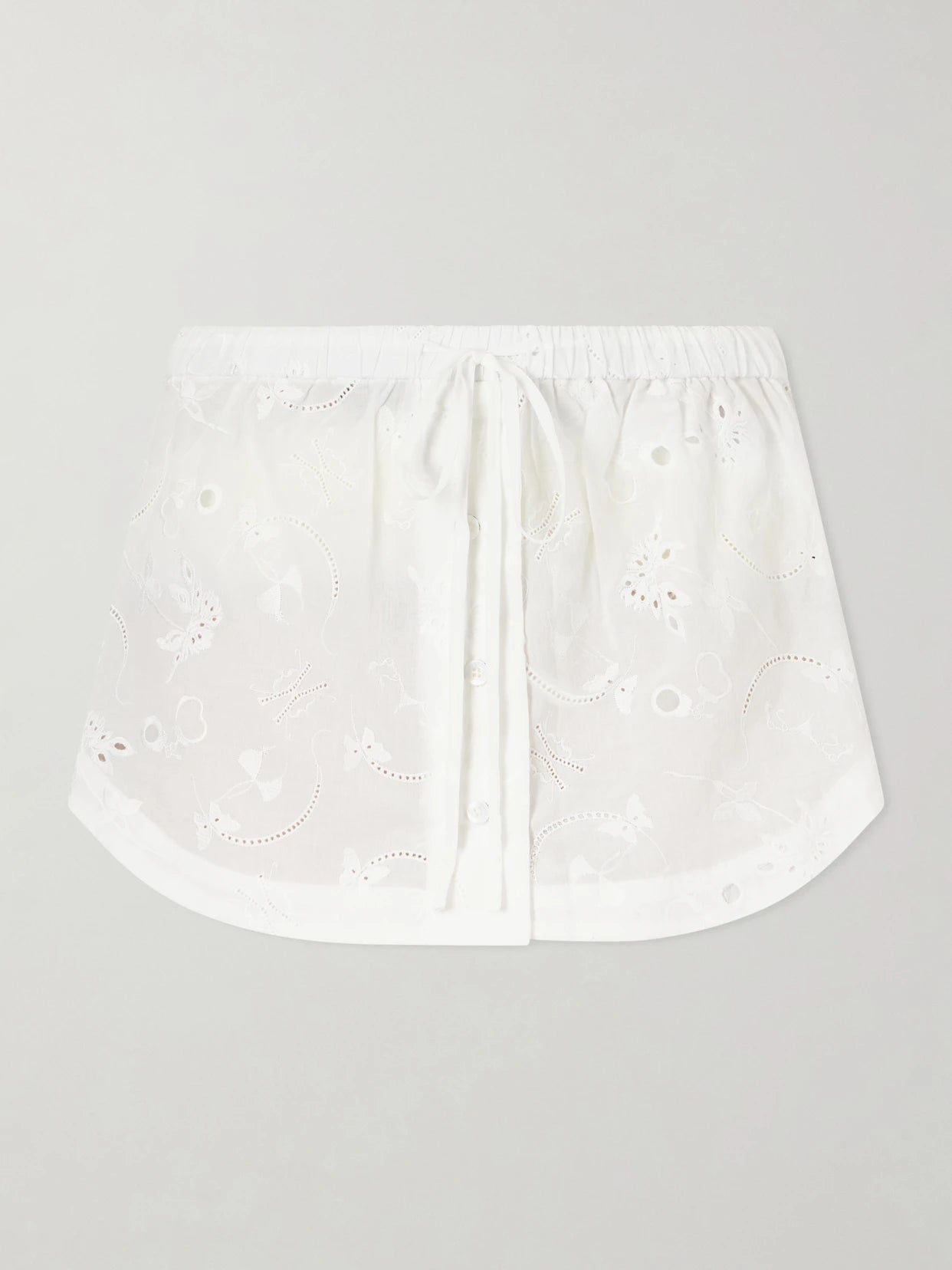 Image of a model wearing Skirts. Product name - Simone Broderie Anglaise Cotton Mini Skirt in Ivory colour by brand - Kiki de Montparnasse
