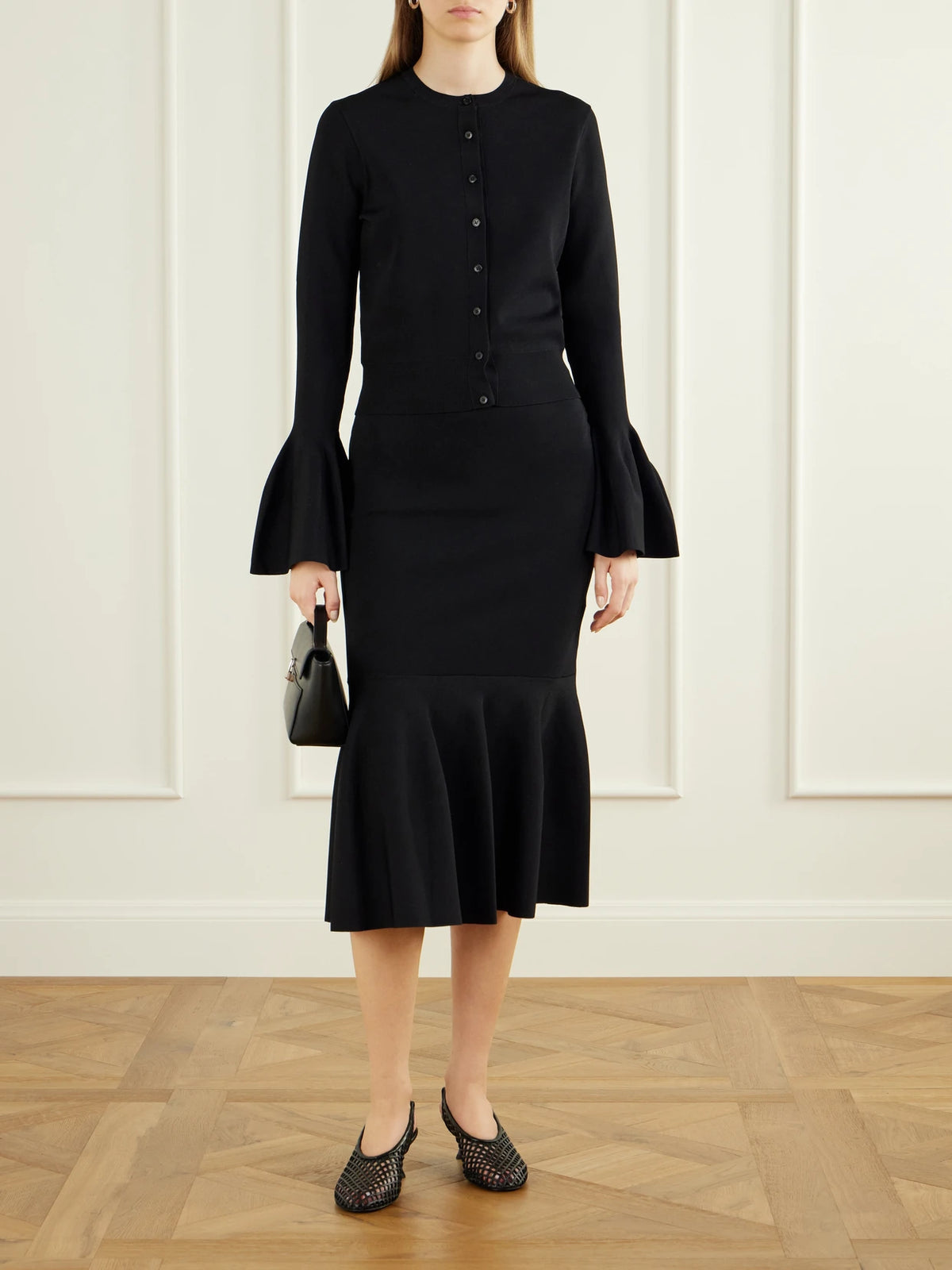 Image of a model wearing Skirts. Product name - Flared Crepe Midi Skirt in Black colour by brand - Stella McCartney