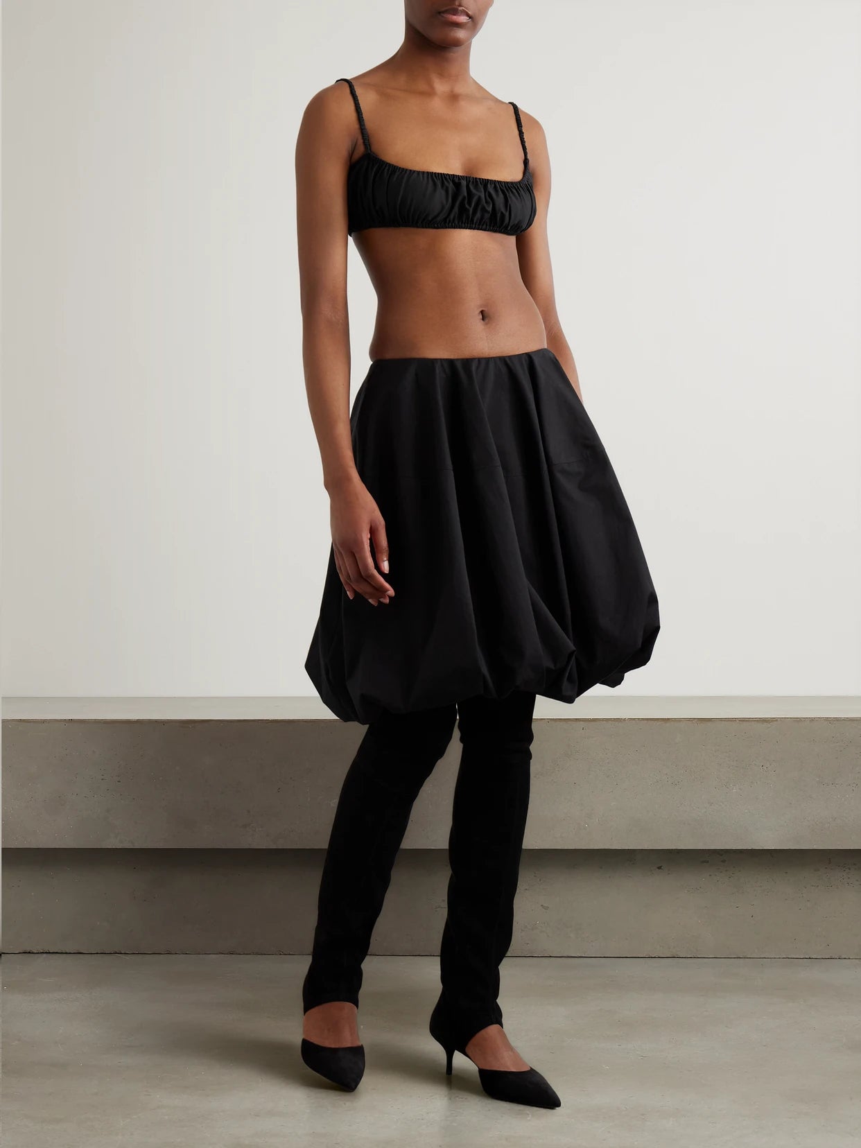 Image of a model wearing Tops. Product name - Gathered Cotton-poplin Bralette in Black colour by brand - Alaïa