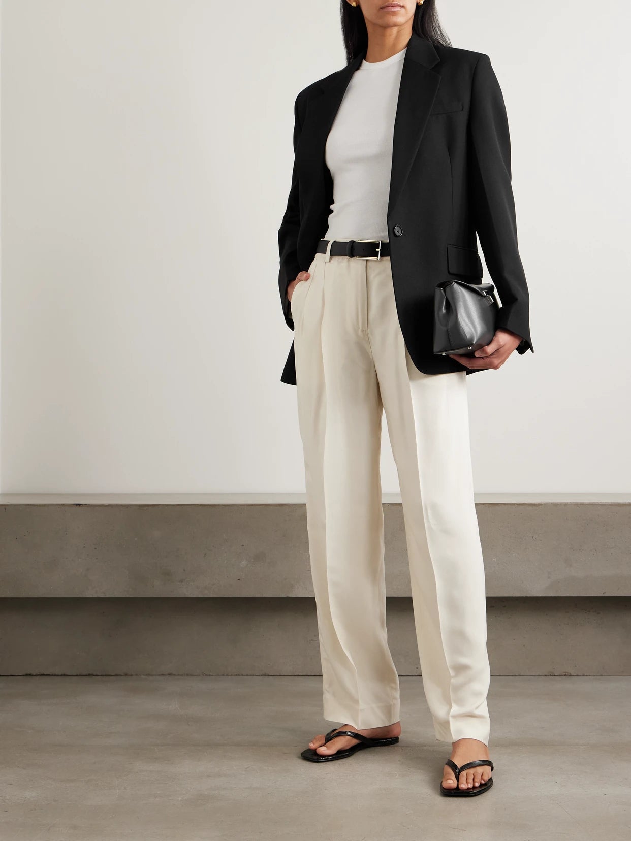 Image of a model wearing Outerwear. Product name - Garderob Oversized Recycled Grain De Poudre Blazer in Black colour by brand - TOTEME