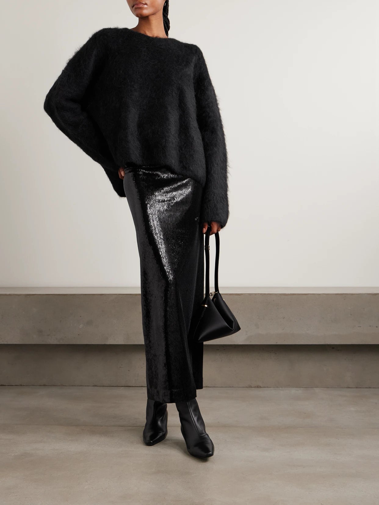 Image of a model wearing Outerwear. Product name - Oversized Ribbed Alpaca-blend Sweater in Black colour by brand - TOTEME