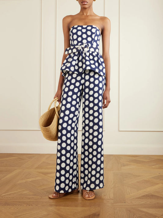Image of a model wearing Tops. Product name - Tilda Strapless Belted Peplum Polka Dot Linen Top in Navy colour by brand - Cara Cara
