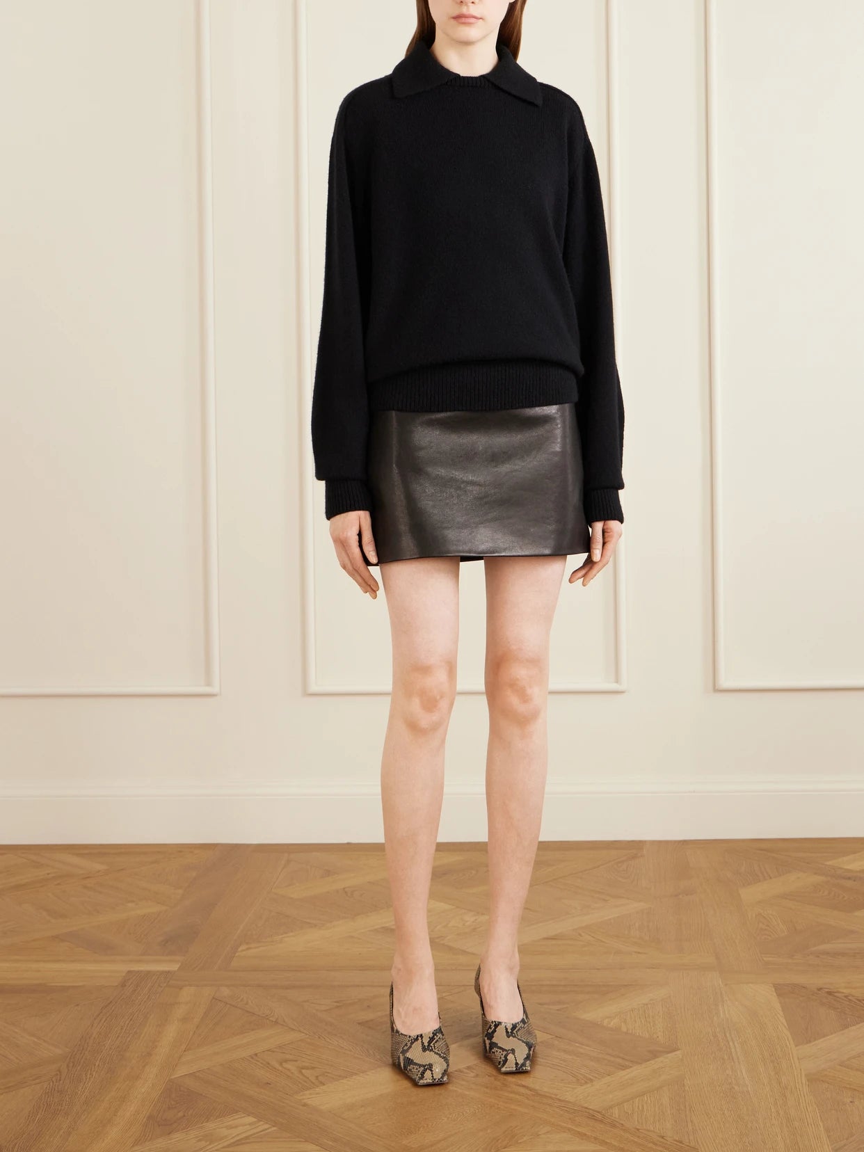 Image of a model wearing Skirts. Product name - Jett Leather Mini Skirt in Black colour by brand - KHAITE