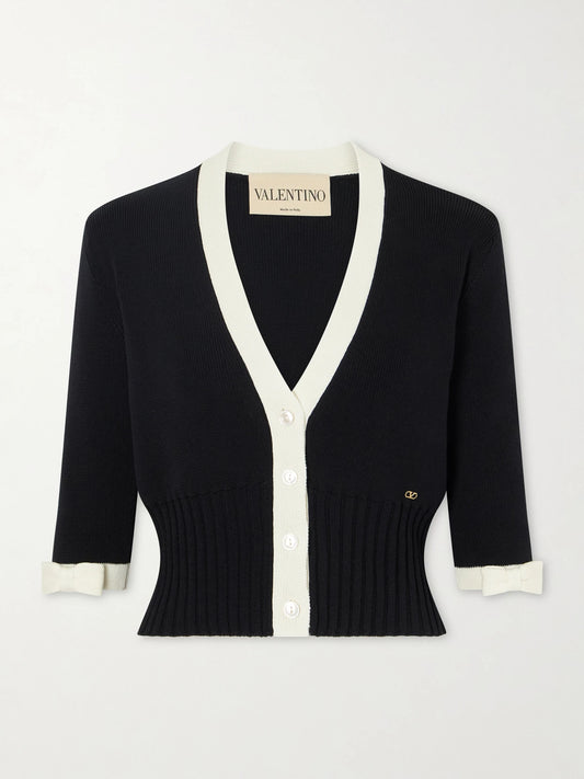 Image of a model wearing Outerwear. Product name - Cropped Bow-embellished Two-tone Ribbed-knit Cotton Cardigan in Black colour by brand - Valentino Garavani
