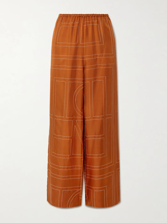 Image of a model wearing Pants. Product name - Embroidered Silk-twill Wide-leg Pants in Orange colour by brand - TOTEME