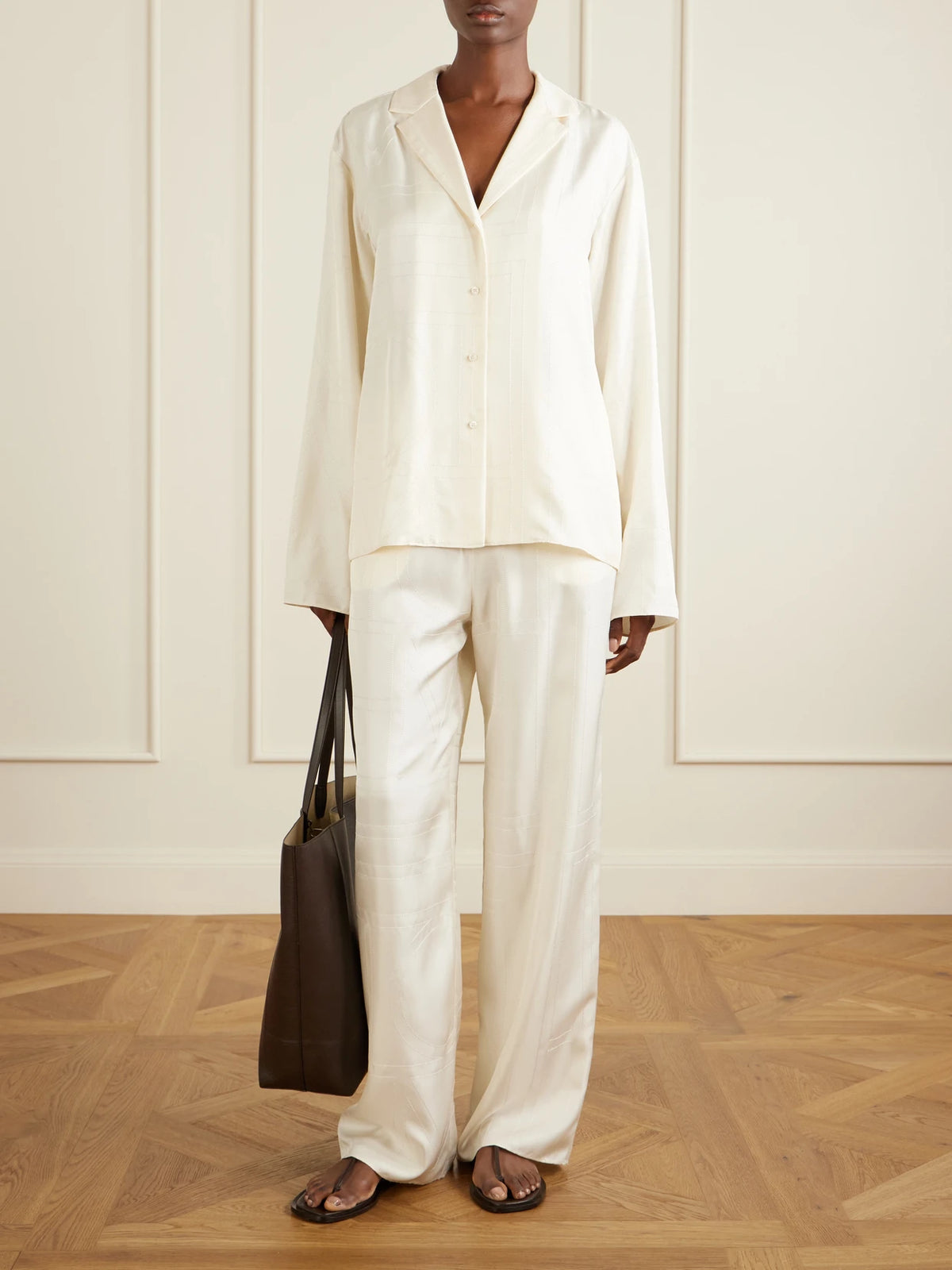 Image of a model wearing Tops. Product name - Embroidered Silk-satin Shirt in Cream colour by brand - TOTEME