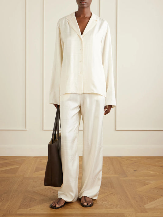 Image of a model wearing Tops. Product name - Embroidered Silk-satin Shirt in Cream colour by brand - TOTEME