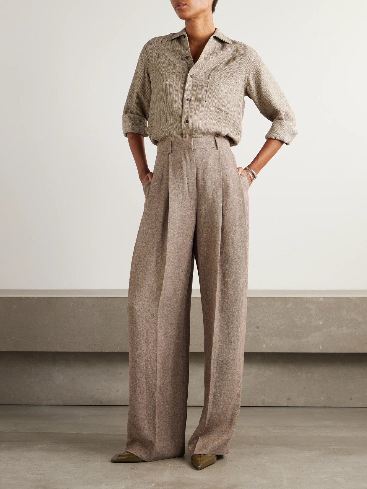Image of a model wearing Pants. Product name - Kurt Pleated Linen Wide-leg Pants in Brown colour by brand - Loro Piana
