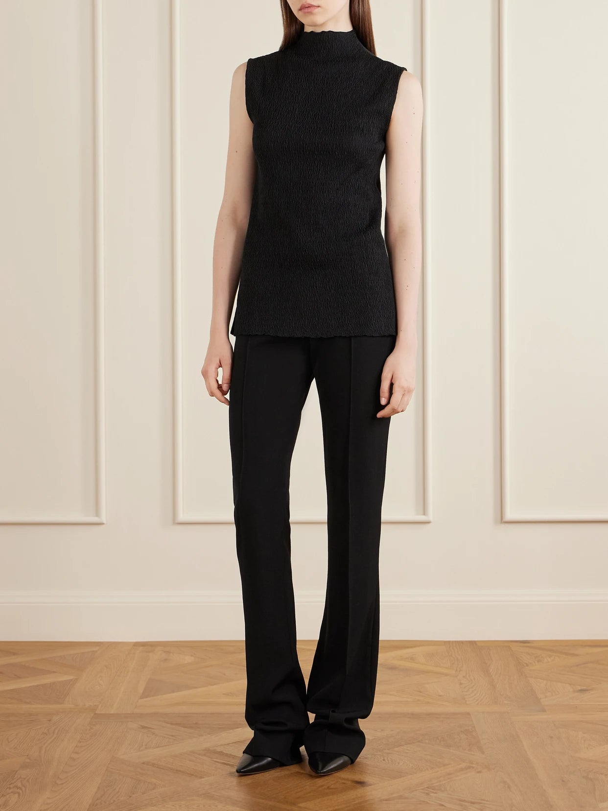 Image of a model wearing Outerwear. Product name - Oakson Silk Plissé Turleneck Sweater in Black colour by brand - The Row