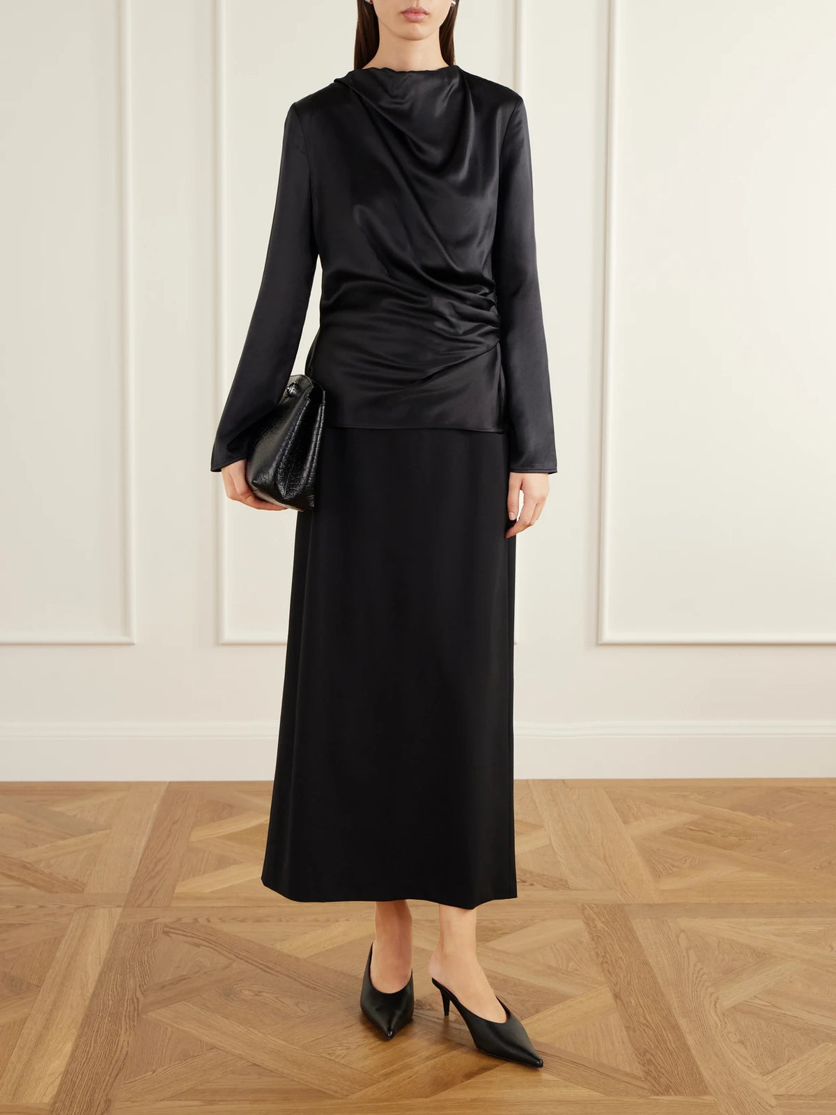 Image of a model wearing Tops. Product name - Anya Gathered Satin Blouse in Black colour by brand - Loulou de Saison