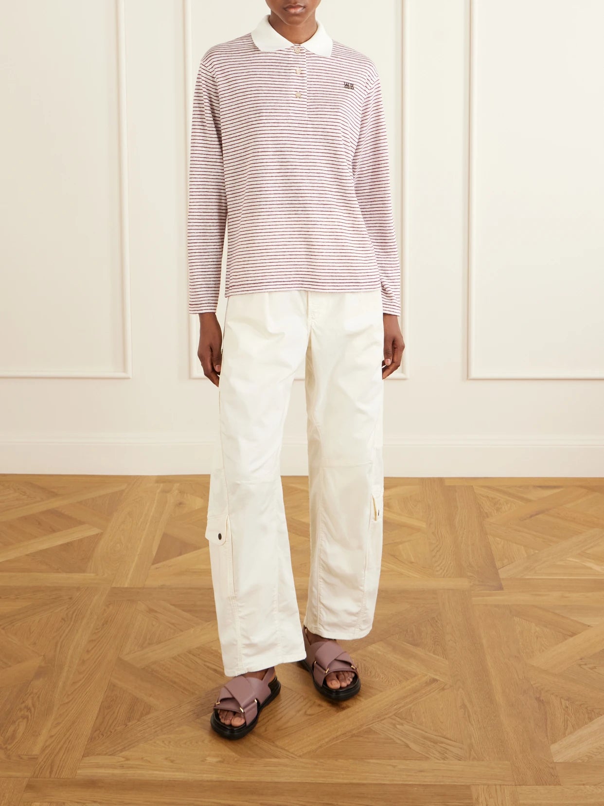 Image of a model wearing Tops. Product name - Trust Logo-embroidered Striped Cotton And Linen-blend Polo T-shirt in Pink colour by brand - Wales Bonner
